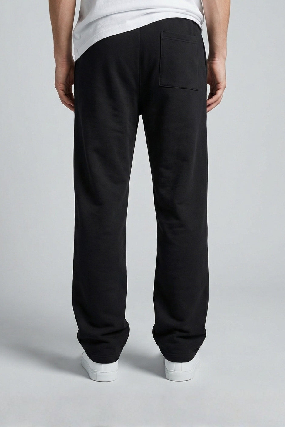 Person wearing black jogger on a plain background