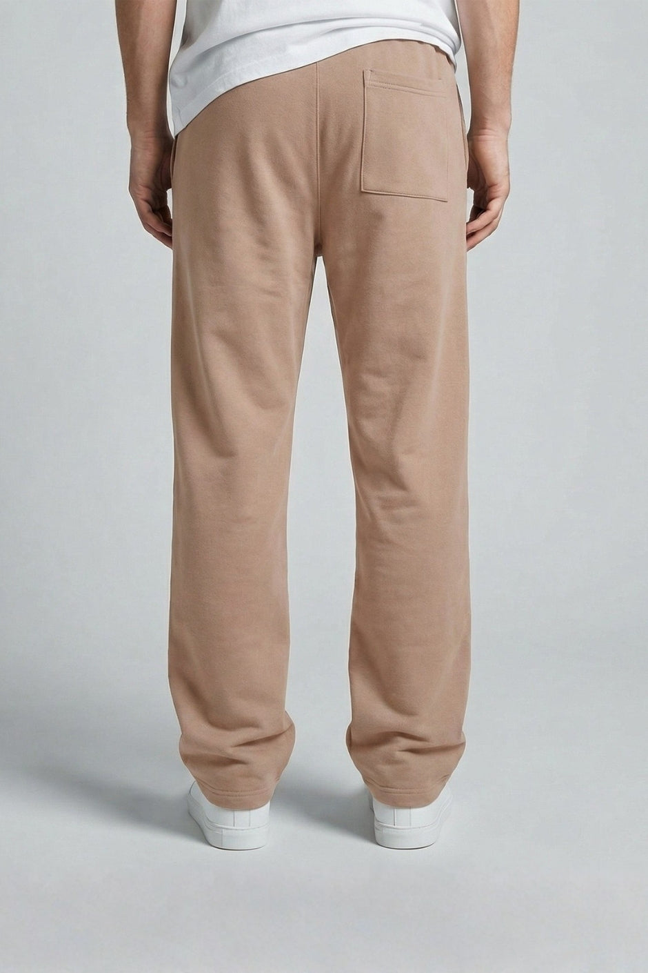 Person wearing light beige jogger on a plain background