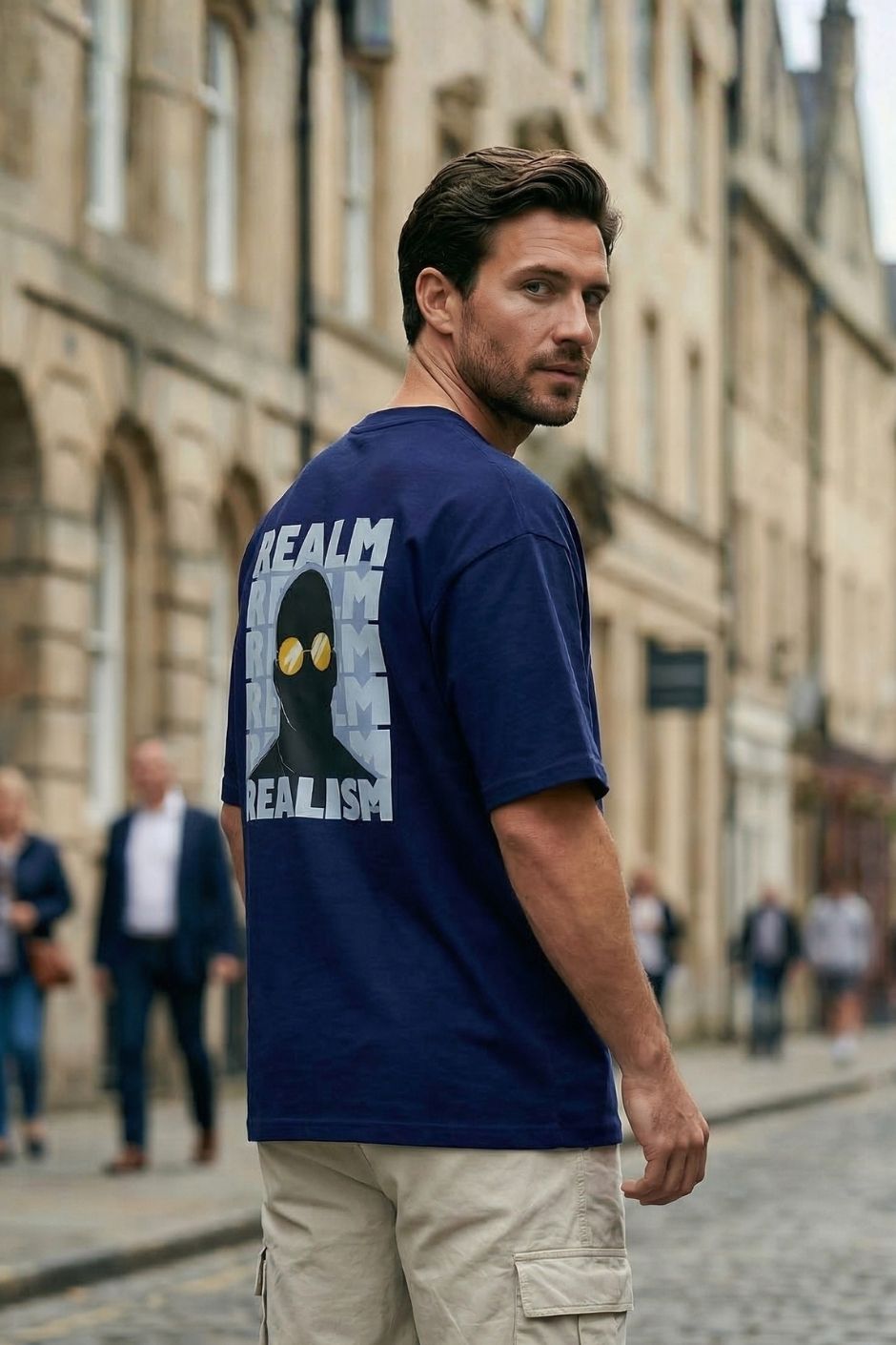 Man wearing a royal blue t-shirt with graphic design on the back in an urban setting