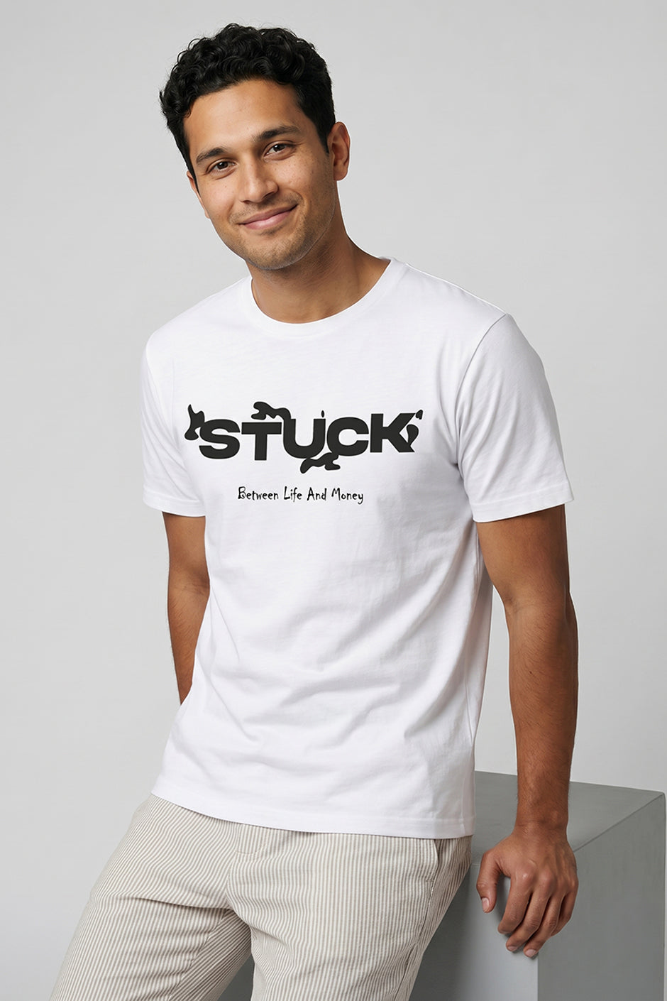 Man wearing a white t-shirt with black text on a light gray background