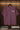 Plum t-shirt with a logo on a hanger against a wooden background