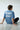 Person wearing a light blue t-shirt with 'Artistic street' text sitting on a concrete floor.