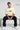 Man sitting on a bench wearing an oversized off white t-shirt with text, black pants, and white sneakers.
