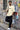 Man posing against a graffiti-covered wall