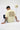 Person wearing a off white t-shirt with 'Empire State of Mind' text, sitting on a white floor.