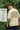 Man wearing a offwhite t-shirt with 'Empire State of Mind' text, standing in a natural setting.