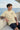 Man sitting on a boat wearing a 'Born to Rise' t-shirt with ocean in the background