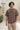 Man wearing a chocolate t-shirt with text, standing indoors.