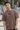 Man wearing a chocolate t-shirt with text, standing outdoors with graffiti in the background