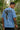 Man wearing a light blue t-shirt with graphic design in a forest setting