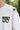 White t-shirt with 'Infinity' logo and text on a blurred green outdoor background