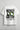 White t-shirt with black and green graphic design on a gray background