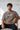 Man wearing an oversized fit t-shirt with 'Let's Go Racing' text, sitting on a chair against a light background.