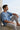 Man sitting by a wall with a scenic ocean view