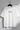 White t-shirt with 'nothing.' text on a hanger against a gray background