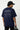 Man wearing a royal blue t-shirt with 'Journey to the Outer Space' text on the back, holding a suitcase.