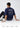Person wearing a royal blue t-shirt with 'Journey to the Outer Space' text, sitting on a white floor.