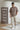 Man wearing a chocolate t-shirt with 'panoramic' branding in a minimalistic room.