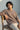 Person wearing a chocolate t-shirt with 'panoramic' text, sitting on a wooden chair against a neutral background.