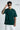 Man wearing a bottle green oversized t-shirt and sunglasses on a white background