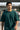 Man wearing a bottle green t-shirt with a blurred background