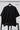 Black oversized t-shirt on a hanger against a white background