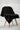 Black tshirt draped over a wooden chair on a light gray background