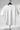 White t-shirt on a hanger against a gray background