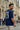 Man wearing a royal blue t-shirt with graphic design on the back in an urban setting