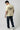 Person wearing a offwhite t-shirt with a graphic design on the back, standing against a plain background.