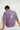 Person wearing a lilac t-shirt with text and graphics, sitting on a white background.