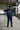 Person wearing a pastel blue t-shirt with 'Savage State' print in an industrial setting