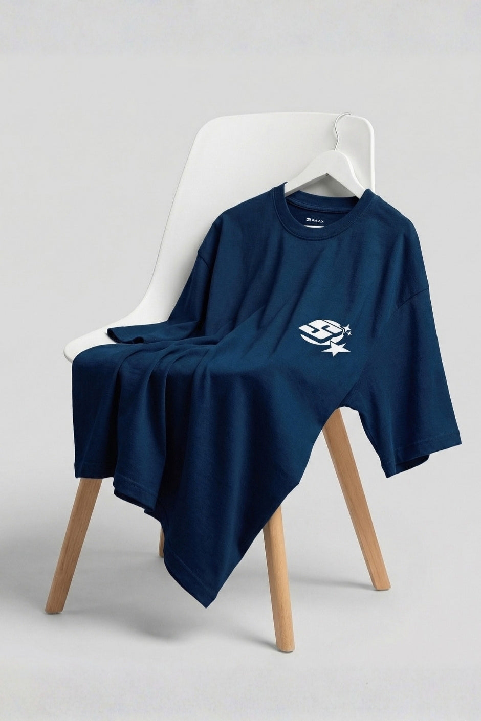 Pastel blue t-shirt with a logo on a white chair against a light gray background