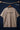 Light beige t-shirt with 'STEREO' print on a hanger against a dark background