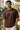 Man wearing a brown t-shirt with text outdoors