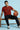 Man sitting on a bench holding a basketball against a light blue background