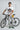 Man holding a bicycle wearing a white t-shirt with a printed design.