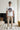 Man wearing a white t-shirt with text and graphics, standing in a modern living room.