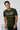 Man wearing a Olive t-shirt with text and graphics on a plain background