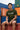 Man sitting on a shipping container with colorful containers in the background