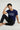 Man wearing a royal blue t-shirt with text, sitting on a light gray background