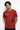 Person wearing a rust t-shirt with a spider graphic and text on a white background
