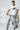 Man holding a bicycle with icons indicating wicking, hydrophobic, and lightweight properties on a gray background.