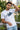 Man wearing a white t-shirt with ' Imperfect' design, standing outdoors.