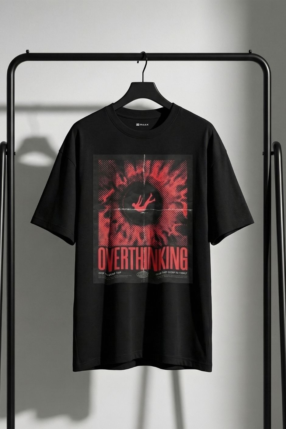 Black t-shirt with red and white graphic design on a hanger against a gray background