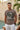 Man wearing a t-shirt with 'OVER THINKING' graphic design by a poolside.