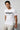 Man wearing a white t-shirt with black text on a light gray background