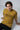 Man wearing a mustard yellow t-shirt with 'TRUST THE PROCESS' text on a white background