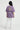 Person wearing a lilac t-shirt with text and graphics on the back, standing against a white background