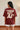 Person wearing a rust t-shirt with 'THIS IS NOT AI' text on the back.